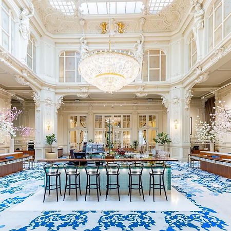 Grandhotel Pupp Κάρλοβι Βάρι Εξωτερικό φωτογραφία The photo shows an elegant interior space, likely a hotel lobby or a high-end establishment. The room features high ceilings adorned with ornate moldings and a large chandelier that hangs prominently from the ceiling. The space is filled with natural