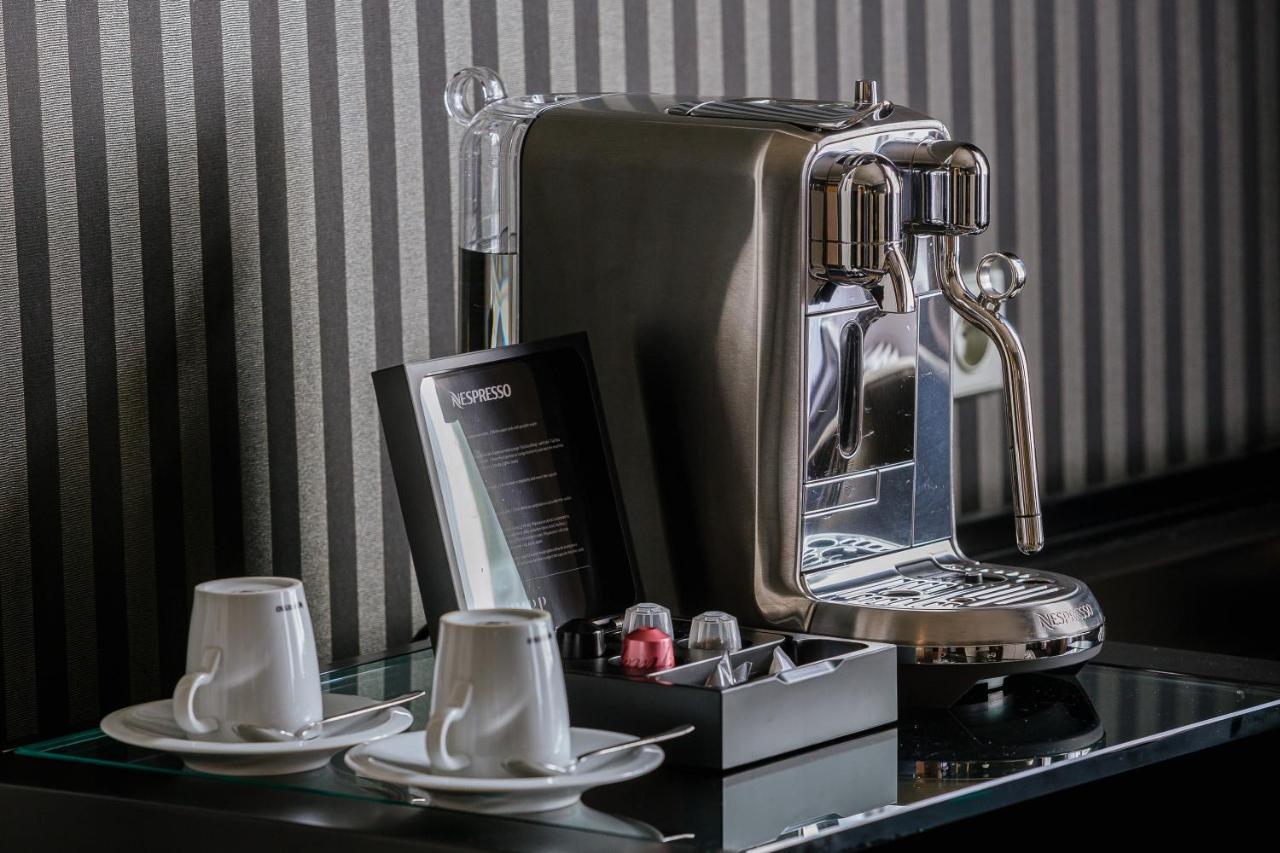 Grandhotel Pupp Κάρλοβι Βάρι Εξωτερικό φωτογραφία The photo shows a sleek, modern coffee machine positioned on a countertop. The machine has a shiny, metallic finish and is equipped with a faucet for dispensing coffee. Next to the coffee machine, there are two white coffee cups on small saucers. In 