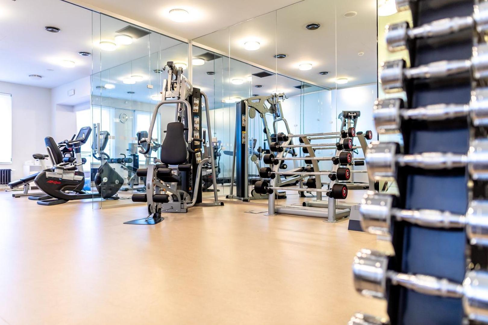 Grandhotel Pupp Κάρλοβι Βάρι Εξωτερικό φωτογραφία The photo shows an interior view of a gym or fitness center. In the foreground, there is a rack of dumbbells arranged by weight, highlighting strength training equipment. In the background, various exercise machines are visible, including a stationar
